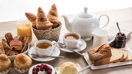 Petit déjeuner - Croissant, thé, brioches, jus d'orange, café, framboise, confiture